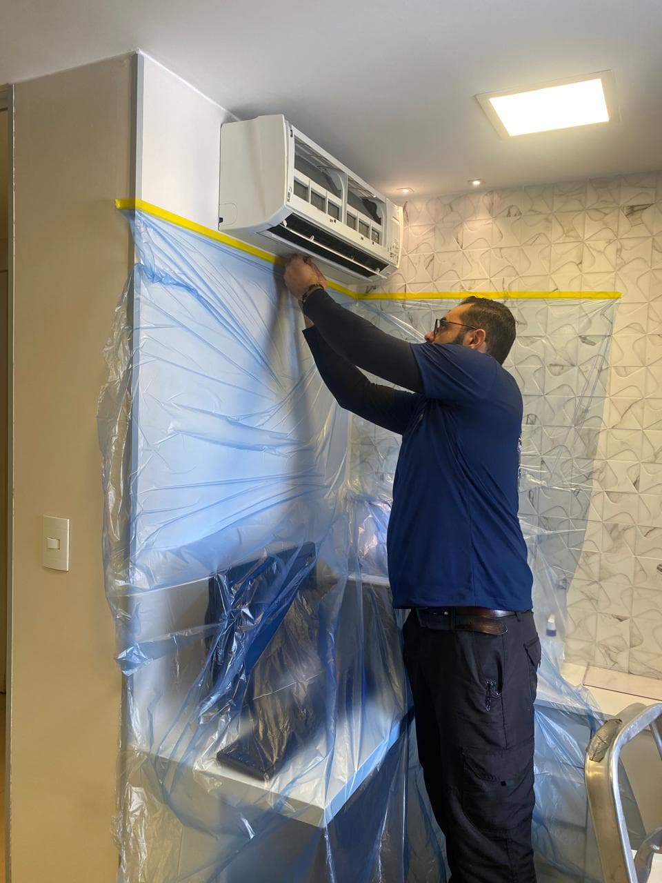 Técnico JC Climatização realizando higienização